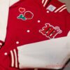 Bruno Mars Hello Kitty Romantic Tour Red Bomber Jacket close-up flat lay view showing front patches and white sleeve