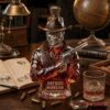 Red Dead Redemption 2 Arthur Morgan Outlaw Bourbon Whiskey Bottle close-up on a vintage desk next to a glass of whiskey